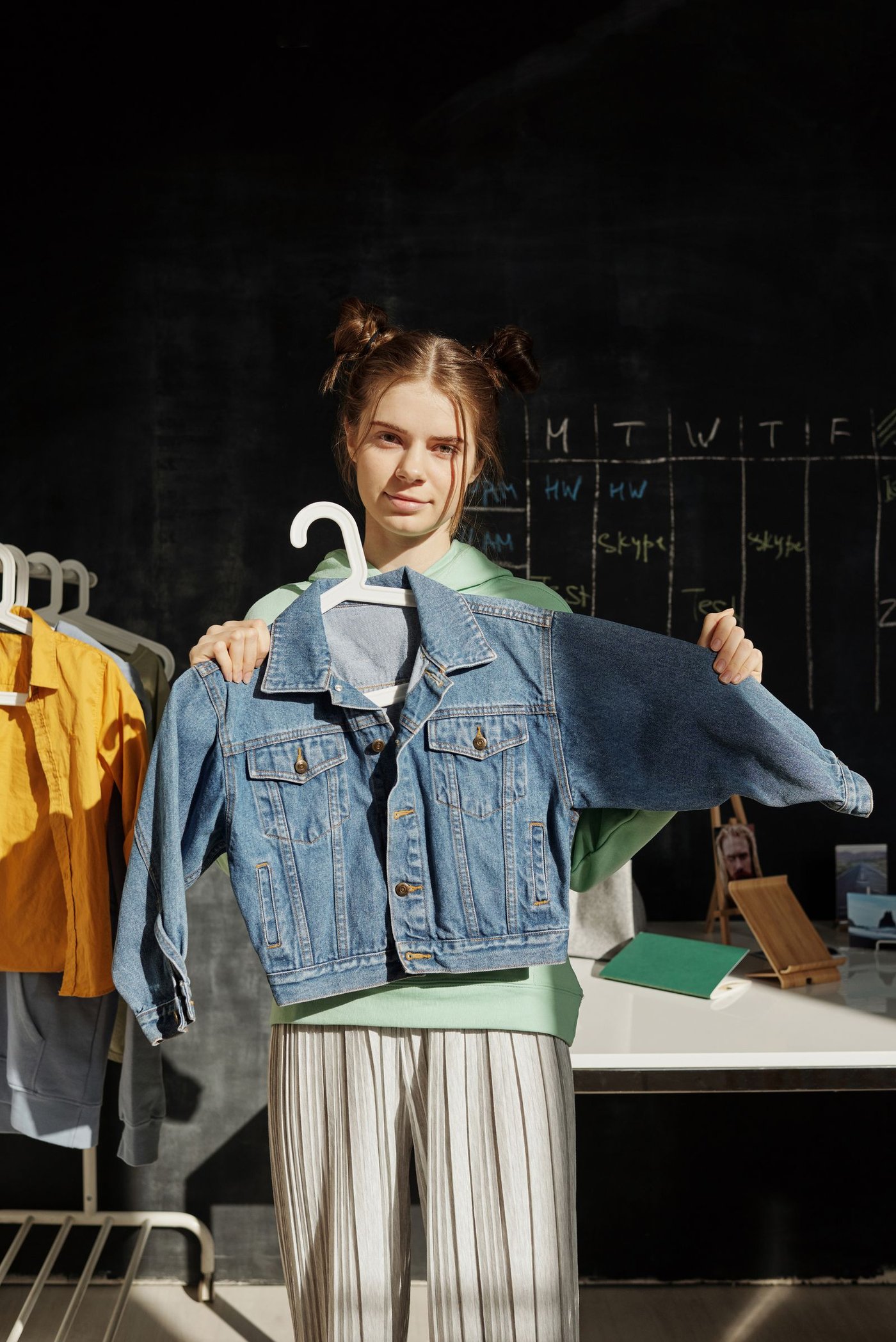 Woman holding a denim jacket in a studio