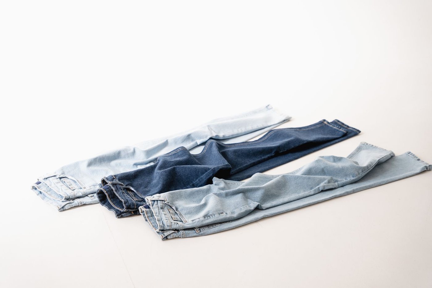 Folded blue jeans on a white background