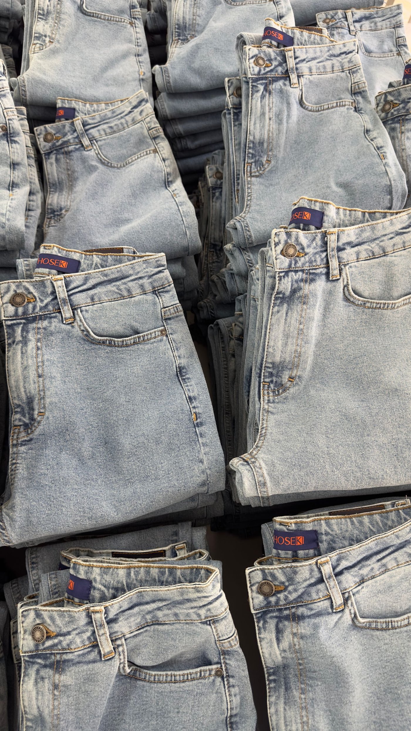 Home Pairs of jeans displayed on a rail in a store