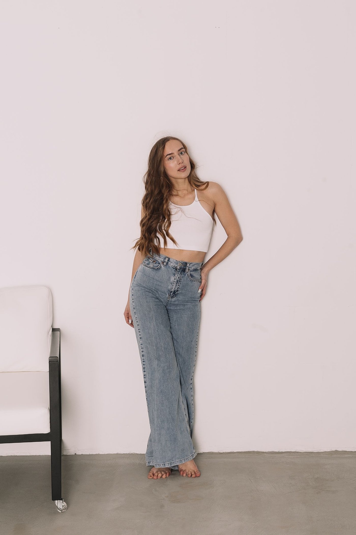 Home Woman in high-waisted blue jeans in a studio
