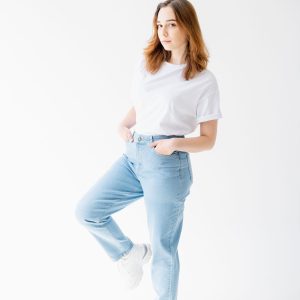 Home Woman in slim blue jeans on a white studio background