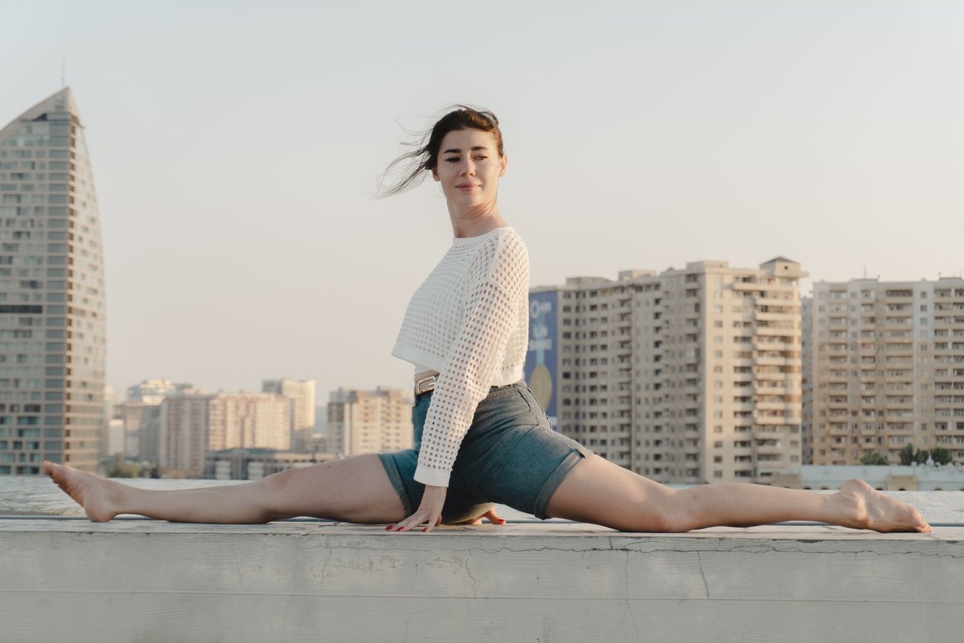 Home Woman in denim shorts sitting on an open city street