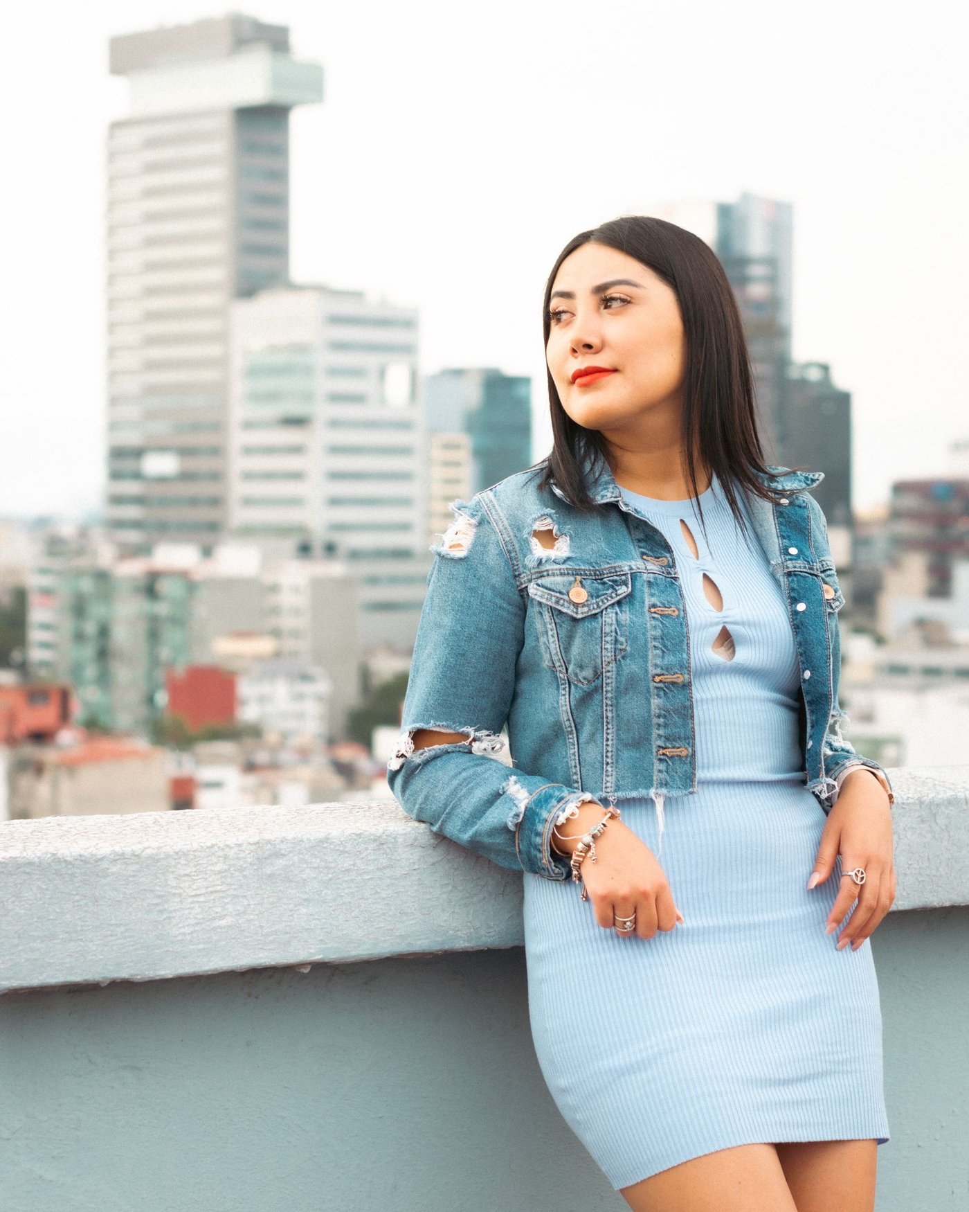 Woman wearing a light denim jacket and denim shorts in the city