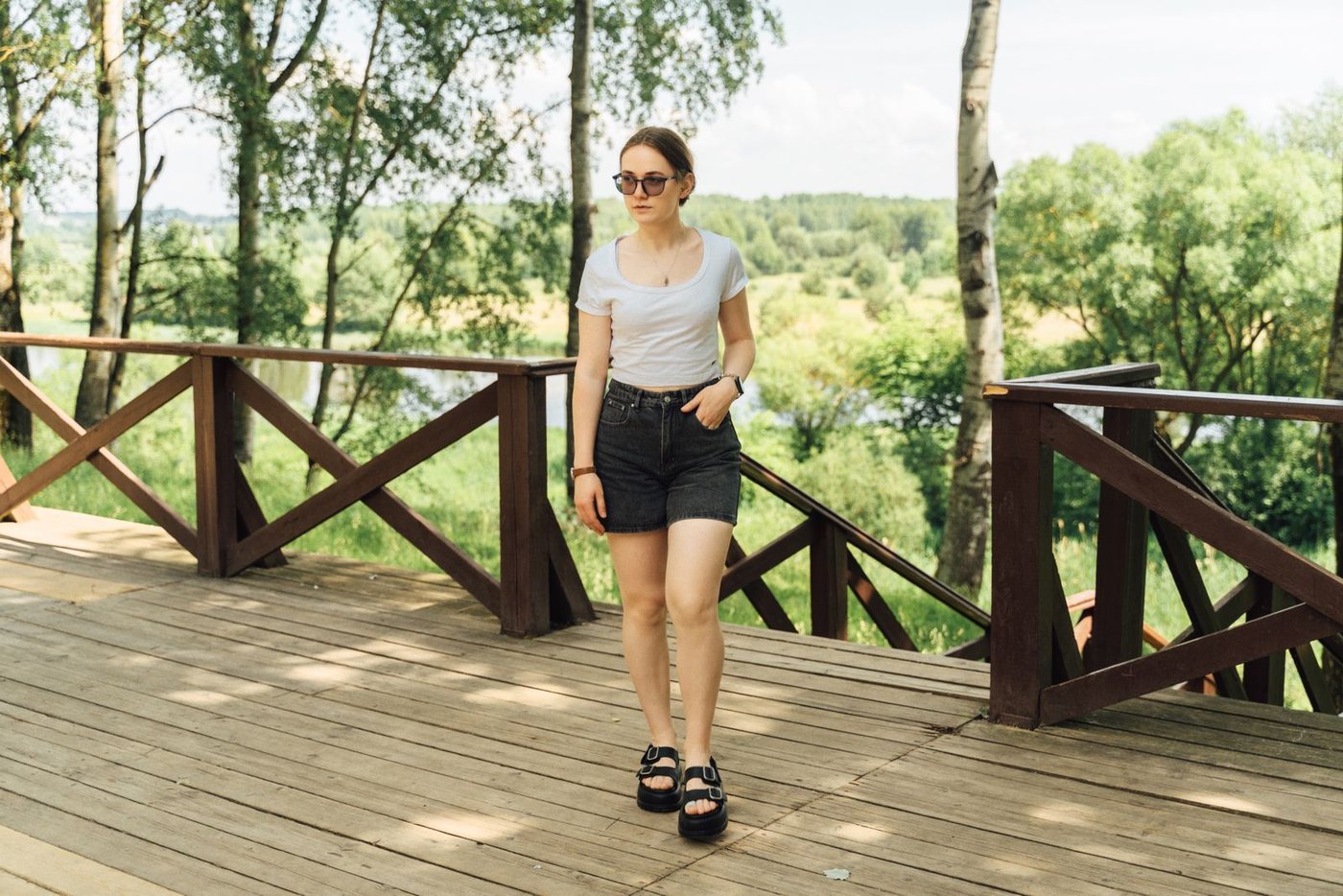 Home Woman in denim shorts walking through a park