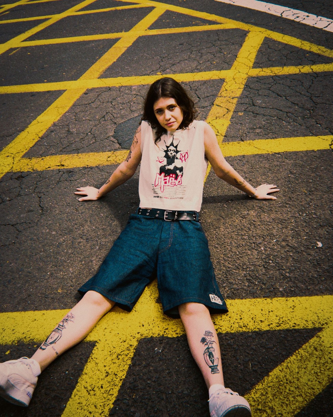 Home Woman in denim dungarees sitting on a painted road